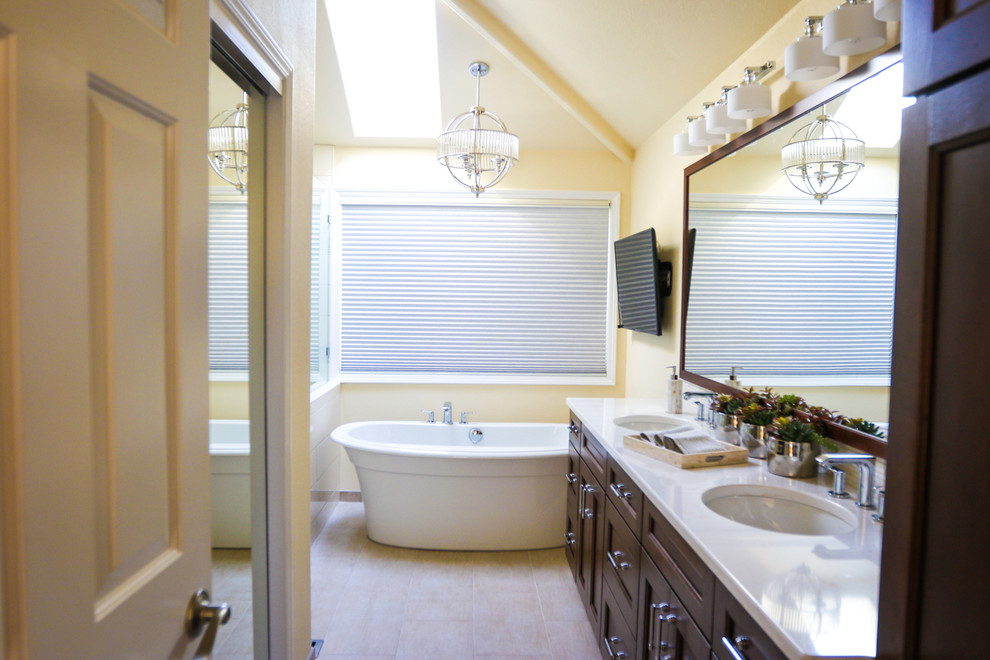 Inspiration for a mid-sized transitional master white tile and subway tile ceramic tile bathroom remodel in Portland with recessed-panel cabinets, dark wood cabinets, beige walls, an undermount sink and solid surface countertops