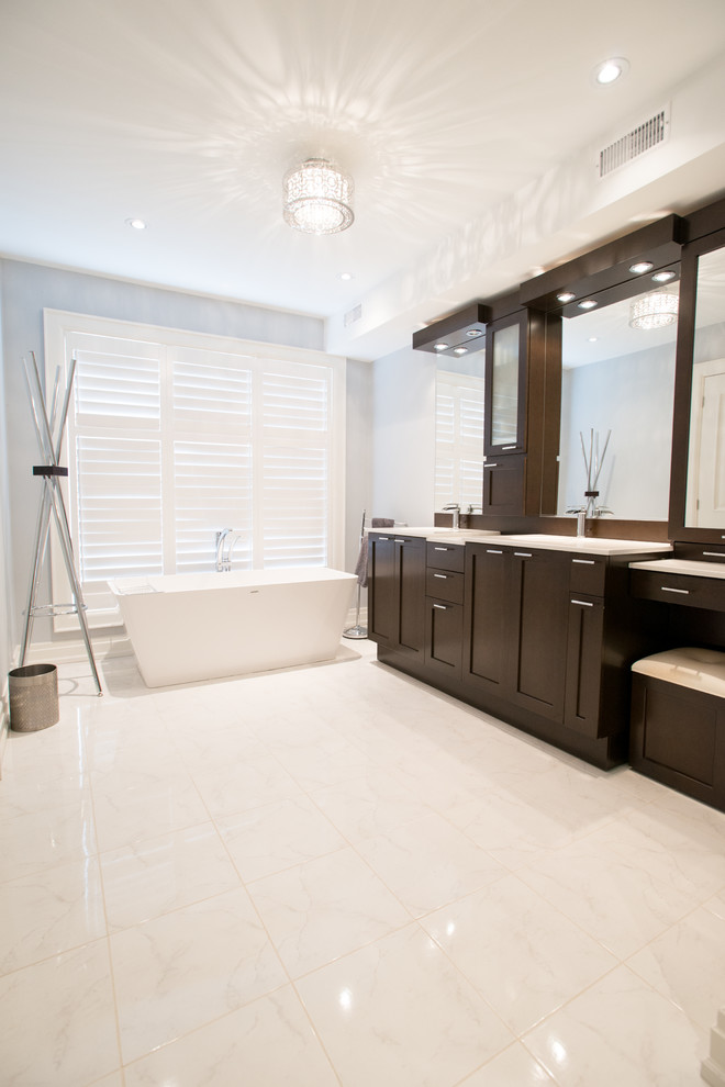 Inspiration for a large classic ensuite bathroom in Toronto with a submerged sink, shaker cabinets, dark wood cabinets, engineered stone worktops, a freestanding bath, white tiles, porcelain tiles, grey walls and porcelain flooring.