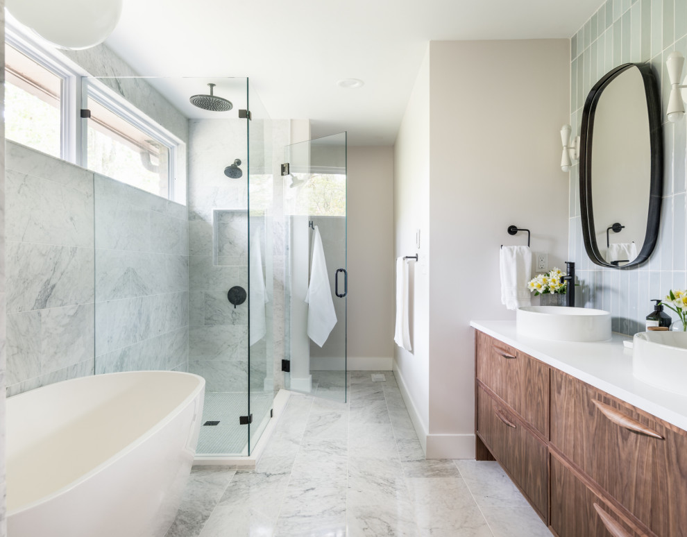 Trendy master blue tile, gray tile and marble tile marble floor, gray floor and double-sink freestanding bathtub photo in Nashville with flat-panel cabinets, medium tone wood cabinets, beige walls, a vessel sink, quartz countertops, a hinged shower door, white countertops and a built-in vanity