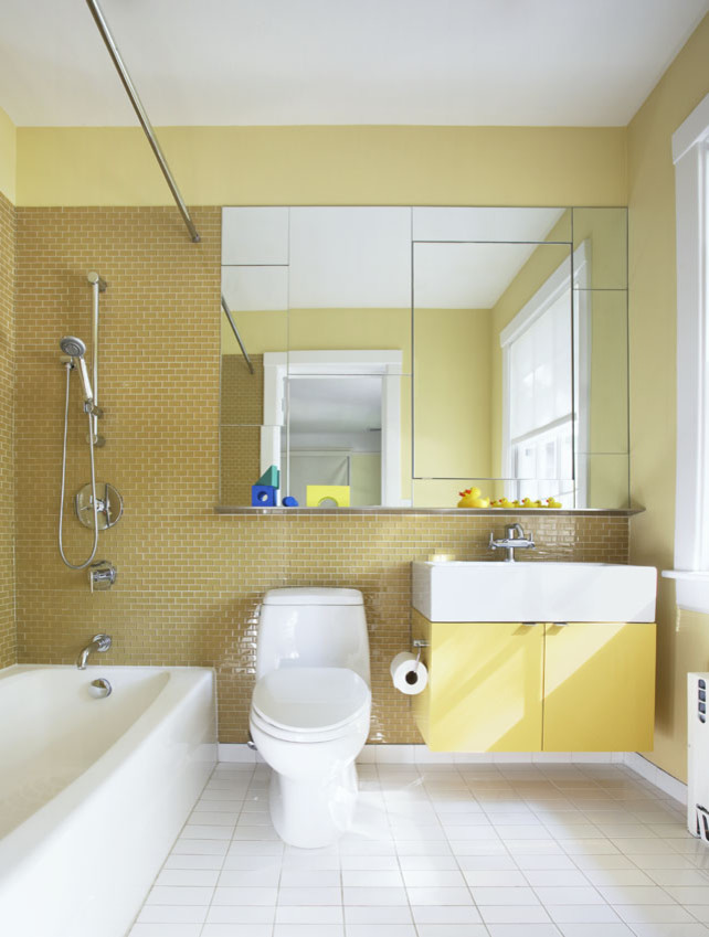 ニューヨークにあるお手頃価格の中くらいなコンテンポラリースタイルのおしゃれな子供用バスルーム (フラットパネル扉のキャビネット、黄色いキャビネット、コーナー型浴槽、シャワー付き浴槽	、分離型トイレ、ベージュのタイル、黄色いタイル、ガラスタイル、黄色い壁、セラミックタイルの床、一体型シンク) の写真