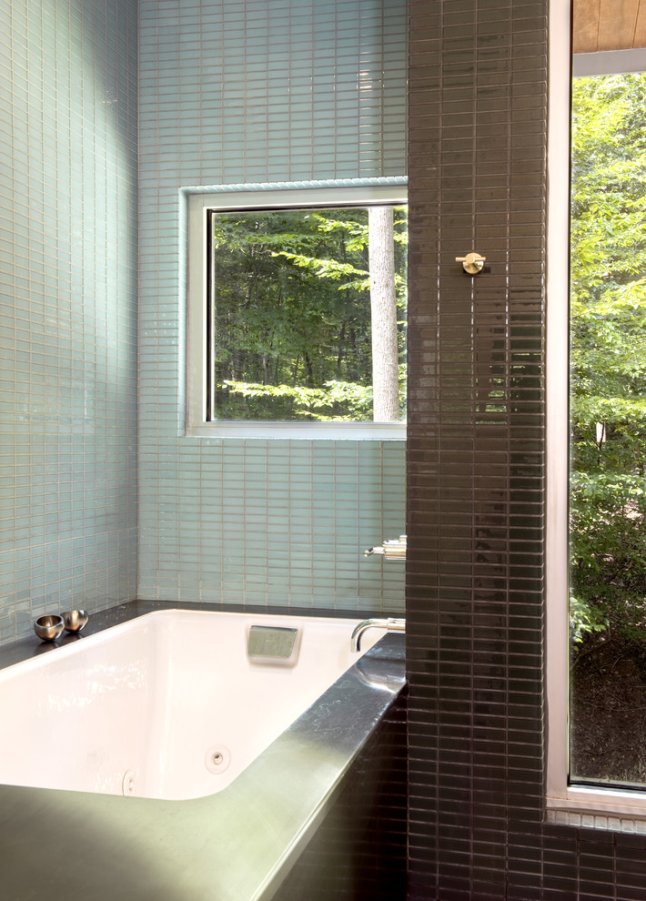 Modelo de cuarto de baño actual con bañera encastrada sin remate, baldosas y/o azulejos azules y ventanas