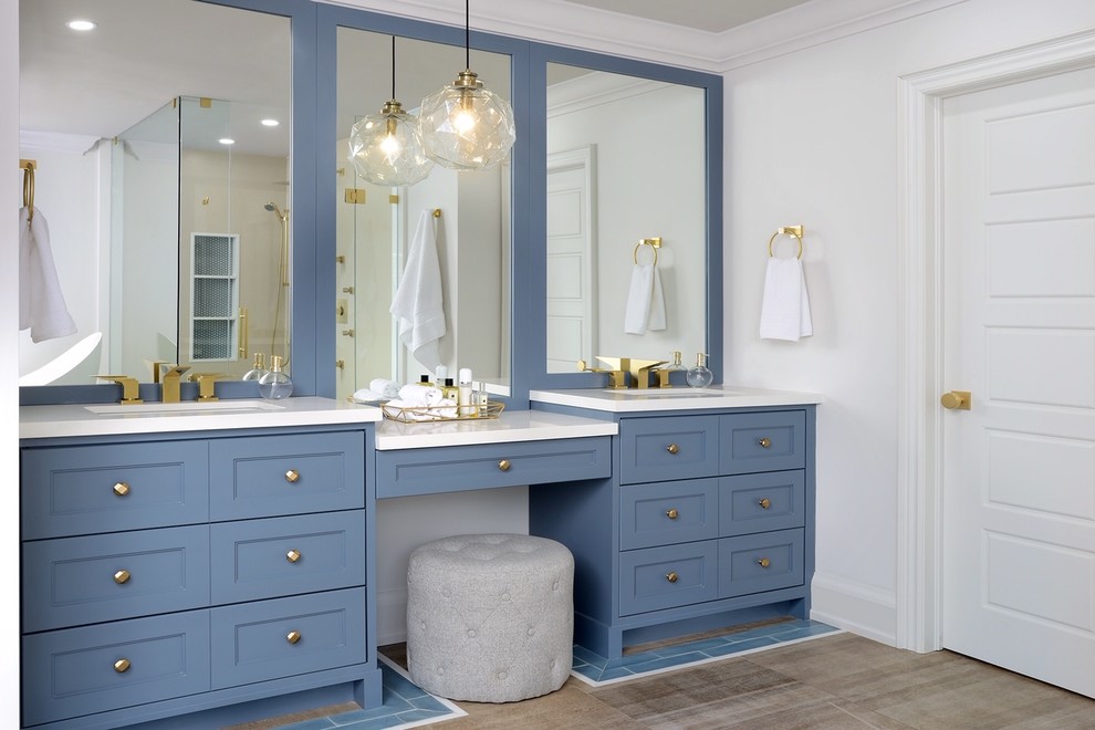 Пример оригинального дизайна: главная ванная комната в стиле неоклассика (современная классика) с фасадами в стиле шейкер, синими фасадами, белыми стенами, врезной раковиной, коричневым полом, белой столешницей и зеркалом с подсветкой