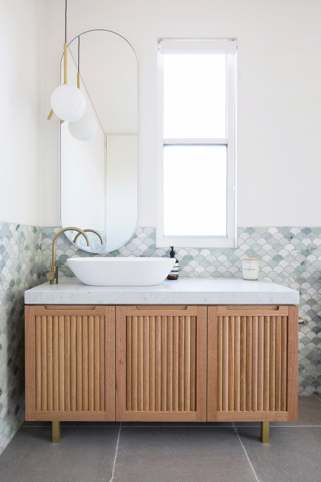 Пример оригинального дизайна: ванная комната в современном стиле с фасадами с филенкой типа жалюзи, бежевыми фасадами, серой плиткой, плиткой мозаикой, белыми стенами, настольной раковиной, серым полом и белой столешницей