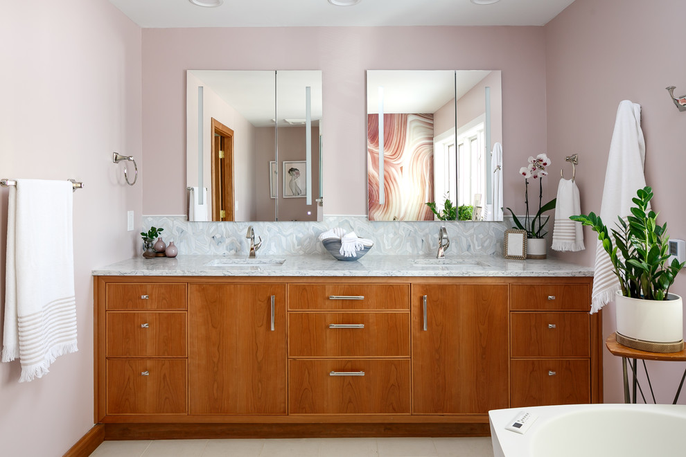Bathroom - mid-sized contemporary master white tile and glass tile porcelain tile and white floor bathroom idea in Louisville with flat-panel cabinets, medium tone wood cabinets, a one-piece toilet, pink walls, an undermount sink, quartz countertops, a hinged shower door and white countertops