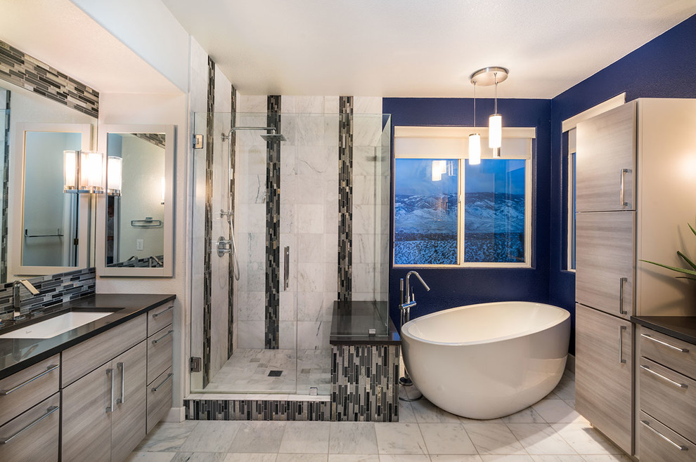 This is an example of a contemporary ensuite bathroom in Other with flat-panel cabinets, brown cabinets, a freestanding bath, a corner shower, beige tiles, porcelain tiles, blue walls, porcelain flooring, a submerged sink, beige floors and a hinged door.