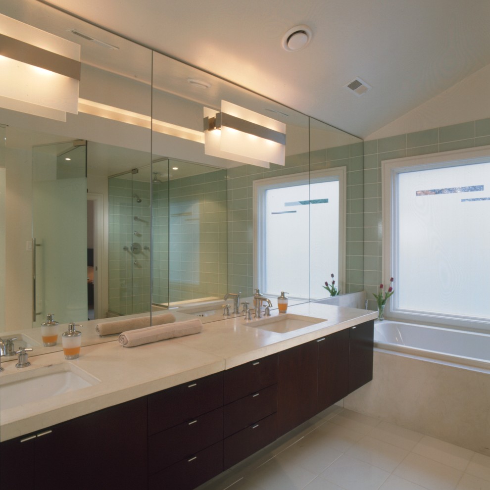 Diseño de cuarto de baño moderno con lavabo bajoencimera, armarios con paneles lisos, puertas de armario de madera en tonos medios, bañera encastrada y baldosas y/o azulejos beige