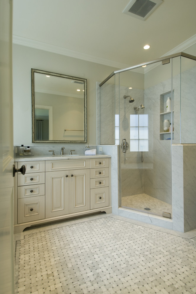 Immagine di una stanza da bagno chic con ante con bugna sagomata, ante beige, doccia ad angolo e piastrelle bianche