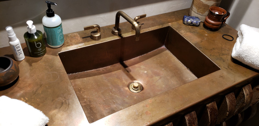 Cette image montre une salle de bain chalet avec un plan de toilette en cuivre.