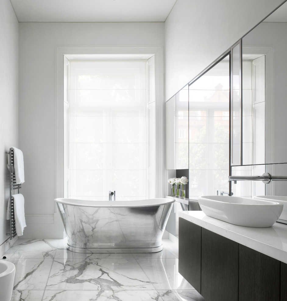 ロンドンにあるコンテンポラリースタイルのおしゃれなマスターバスルーム (フラットパネル扉のキャビネット、濃色木目調キャビネット、置き型浴槽、白い壁、ベッセル式洗面器) の写真
