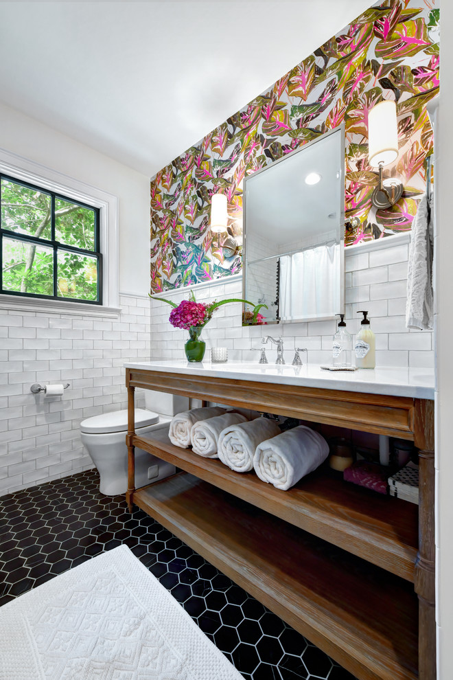 チャールストンにあるトランジショナルスタイルのおしゃれな浴室 (オープンシェルフ、白いタイル、サブウェイタイル、白い壁、モザイクタイル、アンダーカウンター洗面器、黒い床、白い洗面カウンター) の写真