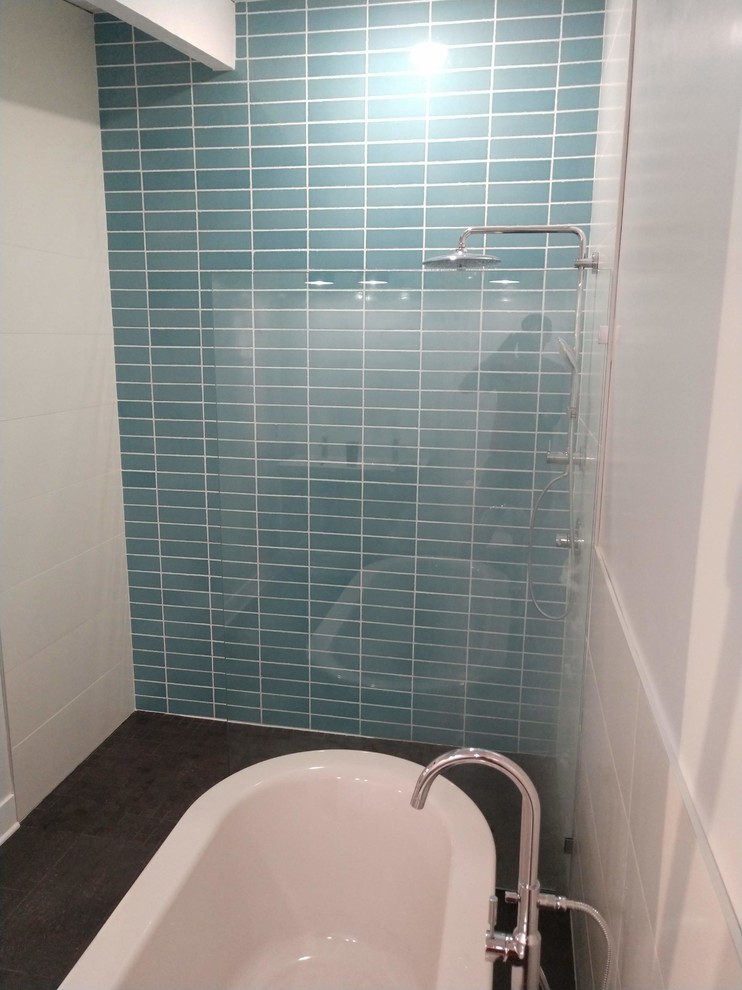 This is an example of a large contemporary ensuite bathroom in Grand Rapids with flat-panel cabinets, a built-in shower, a one-piece toilet, white tiles, ceramic tiles, white walls, porcelain flooring, an integrated sink, grey floors and an open shower.