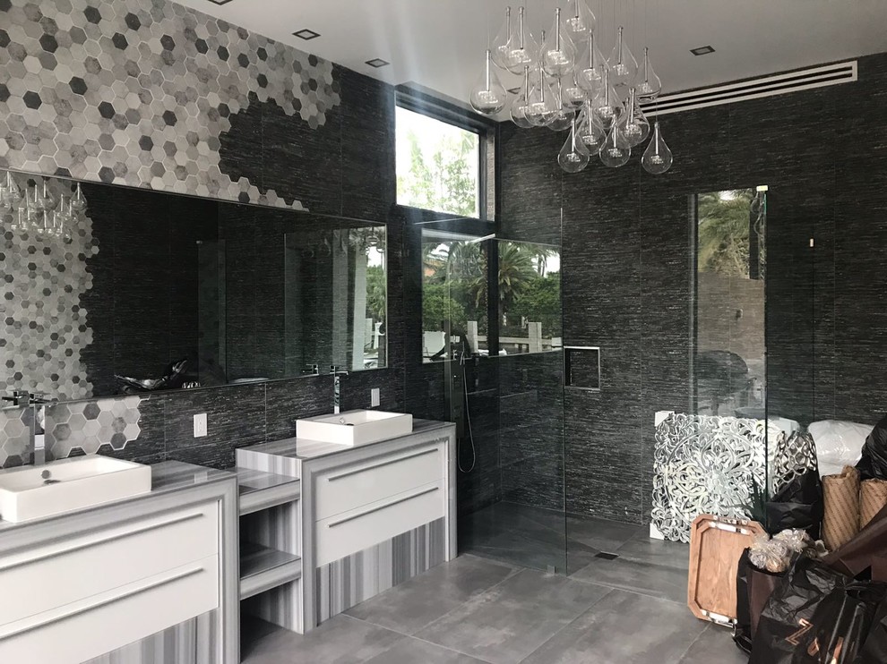 Großes Modernes Badezimmer mit verzierten Schränken, grauen Schränken, Nasszelle, Toilette mit Aufsatzspülkasten, schwarzen Fliesen, Porzellanfliesen, schwarzer Wandfarbe, Porzellan-Bodenfliesen, integriertem Waschbecken, Mineralwerkstoff-Waschtisch, grauem Boden und offener Dusche in Miami