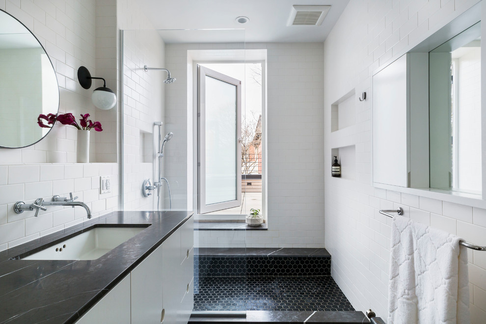 Пример оригинального дизайна: главная ванная комната среднего размера в современном стиле с плоскими фасадами, белыми фасадами, открытым душем, белой плиткой, керамической плиткой, белыми стенами, мраморной столешницей, открытым душем, черной столешницей, полом из мозаичной плитки, врезной раковиной и черным полом