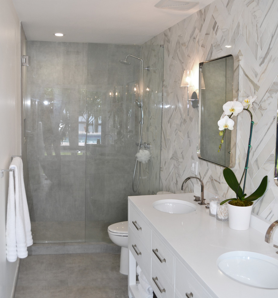 Пример оригинального дизайна: маленькая главная ванная комната в стиле модернизм с белыми фасадами, душем в нише, белой плиткой, мраморной плиткой, серым полом, душем с распашными дверями, фасадами островного типа, отдельно стоящей ванной, унитазом-моноблоком, белыми стенами, бетонным полом, врезной раковиной, столешницей из искусственного кварца и белой столешницей для на участке и в саду