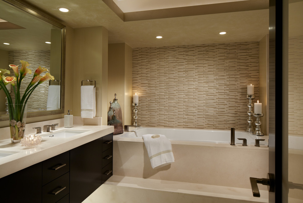 Inspiration for a mid-sized contemporary master beige tile and ceramic tile limestone floor bathroom remodel in Miami with an undermount sink, flat-panel cabinets, dark wood cabinets, limestone countertops, a two-piece toilet and beige walls