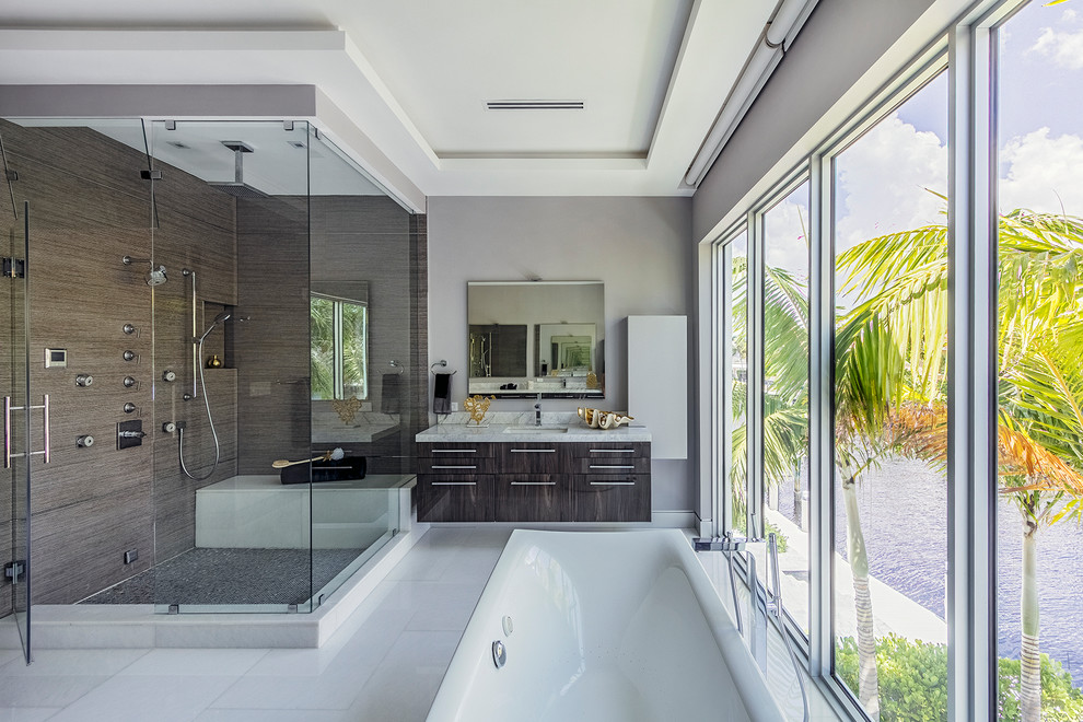 Inredning av ett modernt grå grått en-suite badrum, med släta luckor, skåp i mörkt trä, ett fristående badkar, en dubbeldusch, brun kakel, grå väggar, ett undermonterad handfat, vitt golv och dusch med gångjärnsdörr