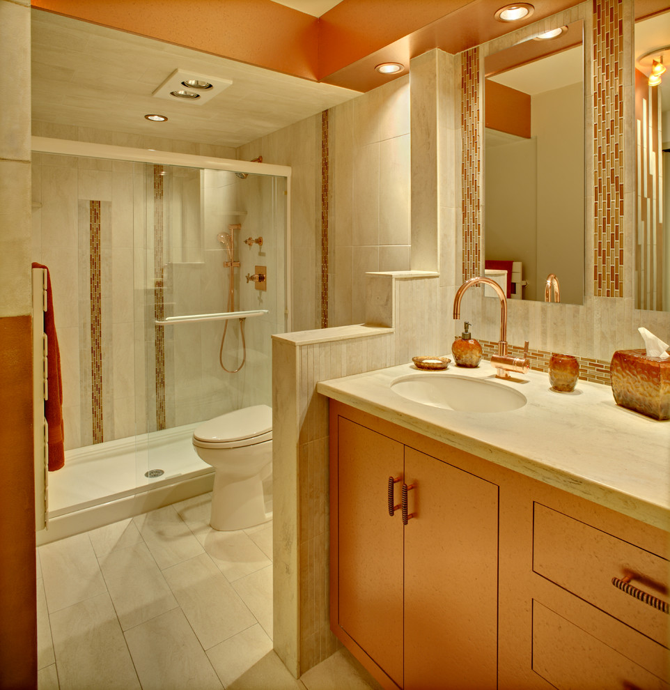 Inredning av ett modernt mellanstort en-suite badrum, med ett undermonterad handfat, släta luckor, beige kakel, porslinskakel, klinkergolv i porslin, orange skåp, bänkskiva i akrylsten, en dusch i en alkov, en toalettstol med hel cisternkåpa och beige väggar