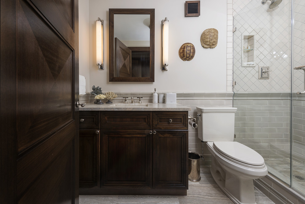 Klassisches Badezimmer mit Schrankfronten mit vertiefter Füllung, dunklen Holzschränken, Duschnische, grauen Fliesen und Metrofliesen in New York