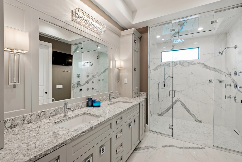 Inredning av ett klassiskt grå grått badrum, med luckor med infälld panel, grå skåp, en dusch i en alkov, vit kakel, bruna väggar, ett undermonterad handfat och vitt golv