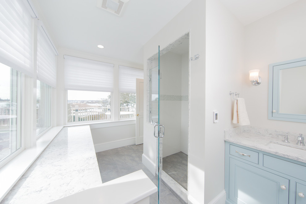 Foto på ett stort maritimt grå en-suite badrum, med luckor med infälld panel, blå skåp, en dusch i en alkov, grå väggar, ett undermonterad handfat, marmorbänkskiva, grått golv och dusch med gångjärnsdörr