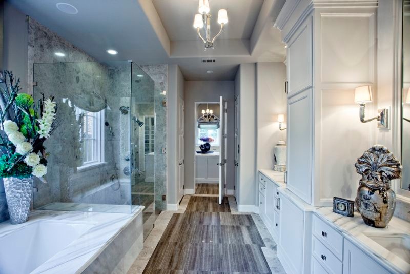 Diseño de cuarto de baño principal tradicional grande con lavabo encastrado, puertas de armario blancas, encimera de mármol, ducha esquinera, paredes grises y suelo de madera en tonos medios