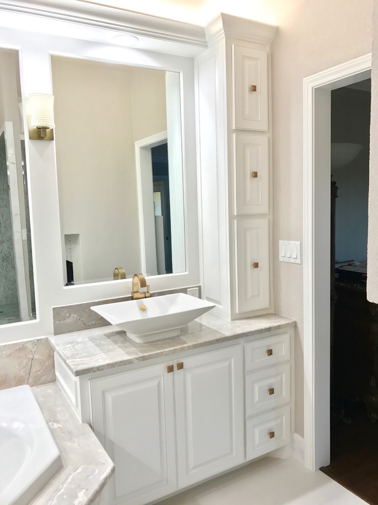 Foto på ett stort vintage en-suite badrum, med luckor med infälld panel, vita skåp, ett hörnbadkar, en öppen dusch, en toalettstol med hel cisternkåpa, vit kakel, porslinskakel, beige väggar, klinkergolv i porslin, ett fristående handfat och bänkskiva i akrylsten