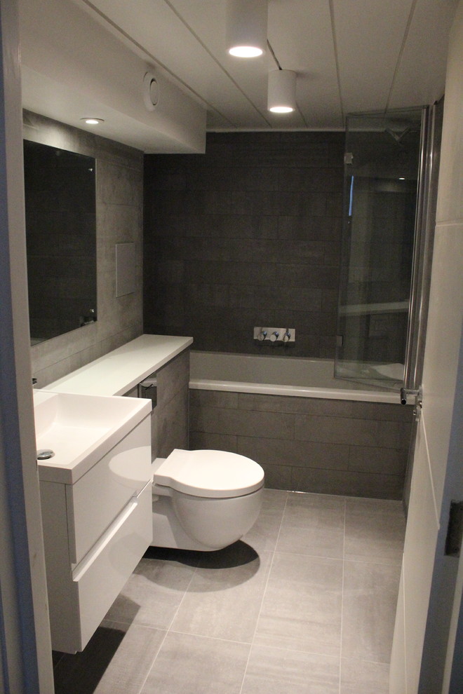 Inspiration för ett mellanstort funkis badrum, med en vägghängd toalettstol, grå kakel, stenkakel och grå väggar
