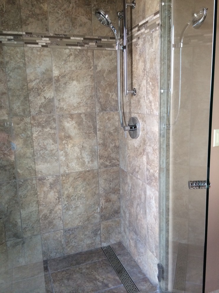 Inredning av ett modernt mellanstort badrum, med ett fristående handfat, släta luckor, skåp i mellenmörkt trä, granitbänkskiva och en dusch i en alkov