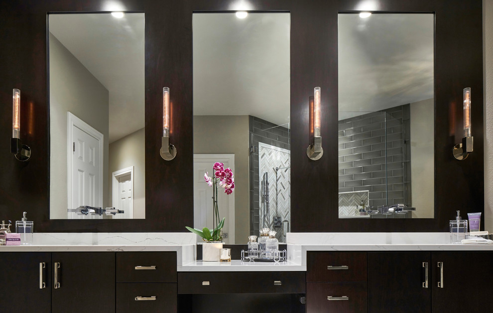 Example of a mid-sized trendy master gray tile and ceramic tile marble floor and white floor freestanding bathtub design in Austin with flat-panel cabinets, dark wood cabinets, a one-piece toilet, gray walls, an undermount sink, quartz countertops and a hinged shower door