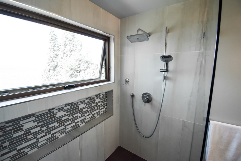 Cette image montre une grande salle de bain principale minimaliste avec un placard à porte plane, des portes de placard beiges, une douche à l'italienne, WC à poser, un mur bleu, un lavabo encastré, un sol noir, aucune cabine et un plan de toilette gris.