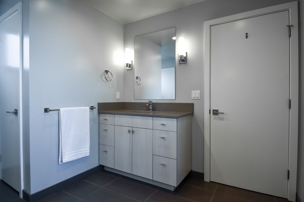 Inspiration pour une grande salle de bain principale minimaliste avec un placard à porte plane, des portes de placard beiges, une douche à l'italienne, WC à poser, un mur bleu, un lavabo encastré, un sol noir, aucune cabine et un plan de toilette gris.