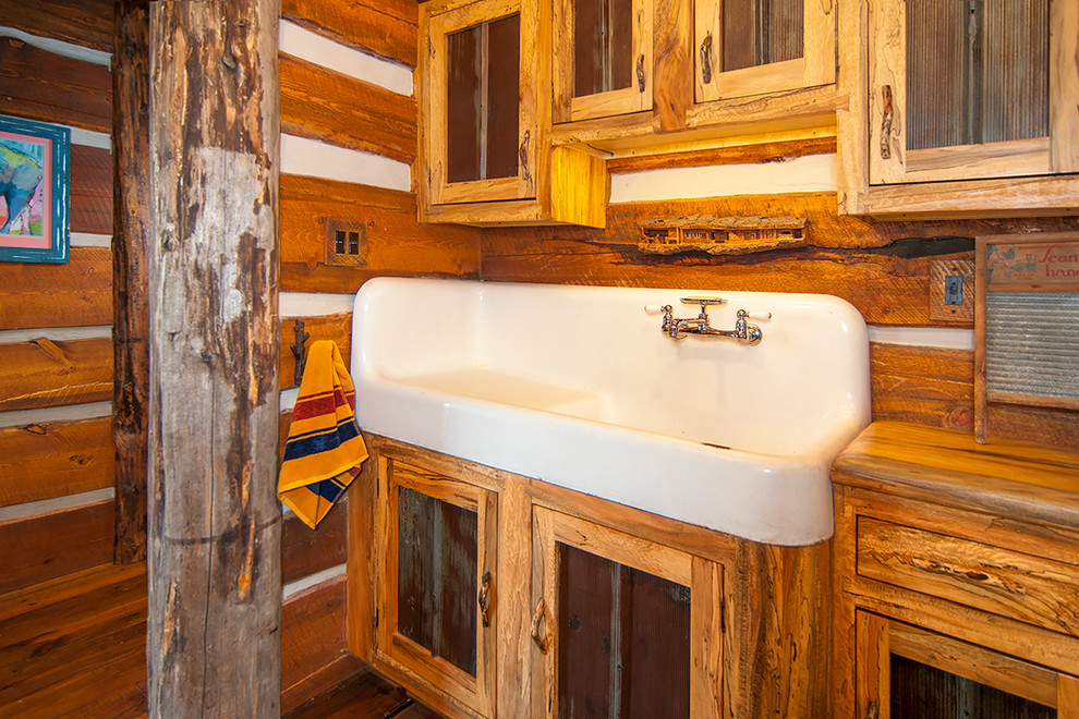 Imagen de cuarto de baño rústico de tamaño medio con armarios tipo mueble, puertas de armario con efecto envejecido, paredes marrones, suelo de madera en tonos medios, aseo y ducha, lavabo de seno grande y encimera de madera