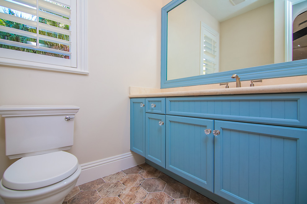 Kleines Country Badezimmer mit grauer Wandfarbe, Quarzwerkstein-Waschtisch, Schrankfronten mit vertiefter Füllung, blauen Schränken, Toilette mit Aufsatzspülkasten, Terrakottaboden und rotem Boden in Miami