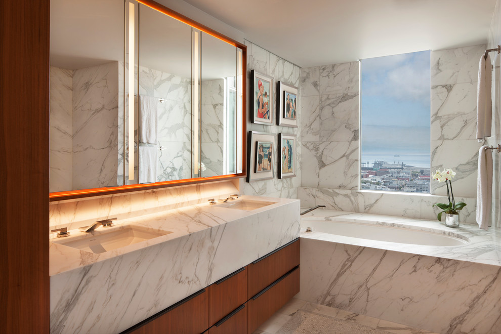 Example of a large minimalist master white tile and mosaic tile marble floor alcove shower design in San Francisco with flat-panel cabinets, medium tone wood cabinets, an undermount tub, a wall-mount toilet, white walls, an undermount sink and marble countertops