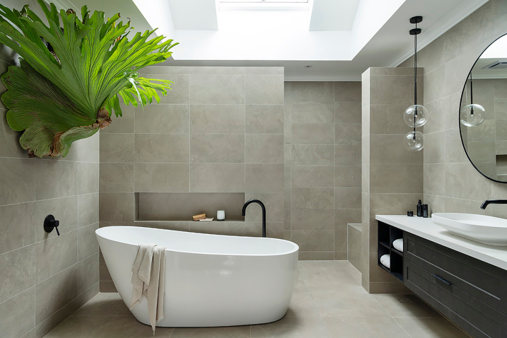Photo of a medium sized contemporary ensuite bathroom in Perth with shaker cabinets, a freestanding bath, double sinks, a built in vanity unit, black cabinets, a walk-in shower, grey tiles, porcelain tiles, porcelain flooring, a vessel sink, grey floors, an open shower, white worktops and a wall niche.