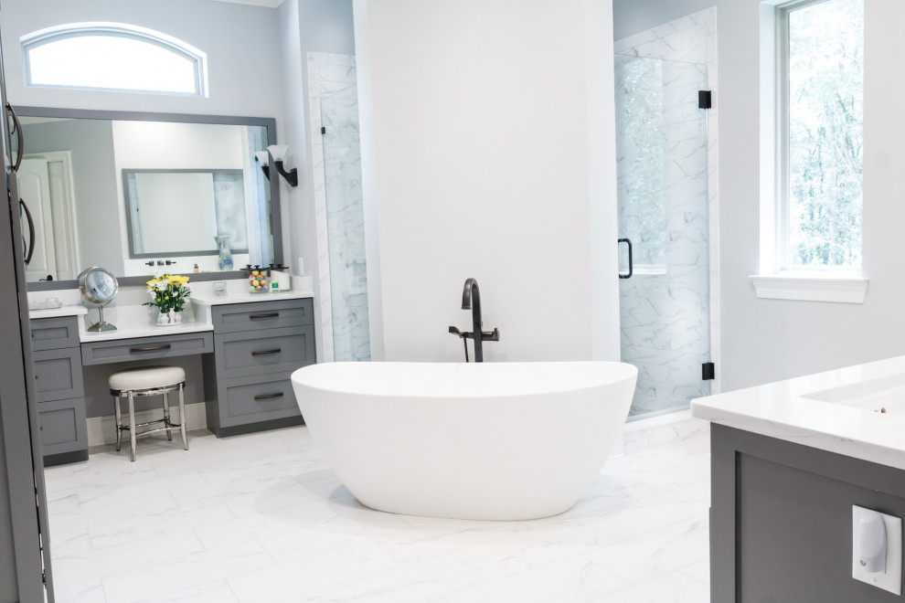Пример оригинального дизайна: большая главная ванная комната в стиле модернизм с фасадами в стиле шейкер, серыми фасадами, отдельно стоящей ванной, угловым душем, унитазом-моноблоком, серой плиткой, керамической плиткой, серыми стенами, полом из керамической плитки, врезной раковиной, столешницей из искусственного кварца, белым полом, душем с распашными дверями, белой столешницей, сиденьем для душа, тумбой под одну раковину и встроенной тумбой