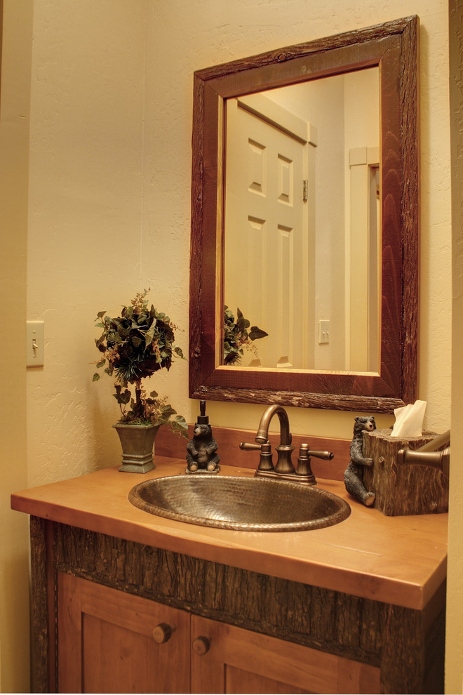 Inspiration pour une salle de bain chalet en bois brun avec un lavabo posé, un placard en trompe-l'oeil et un plan de toilette en bois.