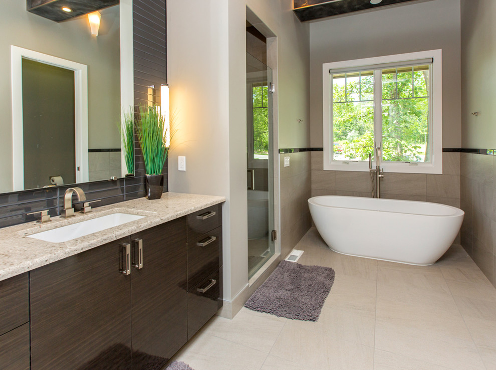 Example of a mid-sized trendy 3/4 gray tile and glass tile ceramic tile bathroom design in Other with flat-panel cabinets, dark wood cabinets, beige walls, an undermount sink and limestone countertops