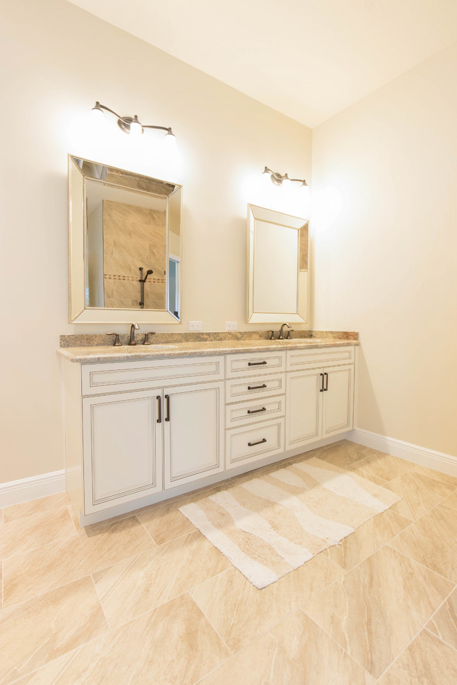 Foto di una stanza da bagno padronale tradizionale di medie dimensioni con ante con bugna sagomata, ante beige, pareti beige, pavimento in gres porcellanato, top in granito e pavimento beige