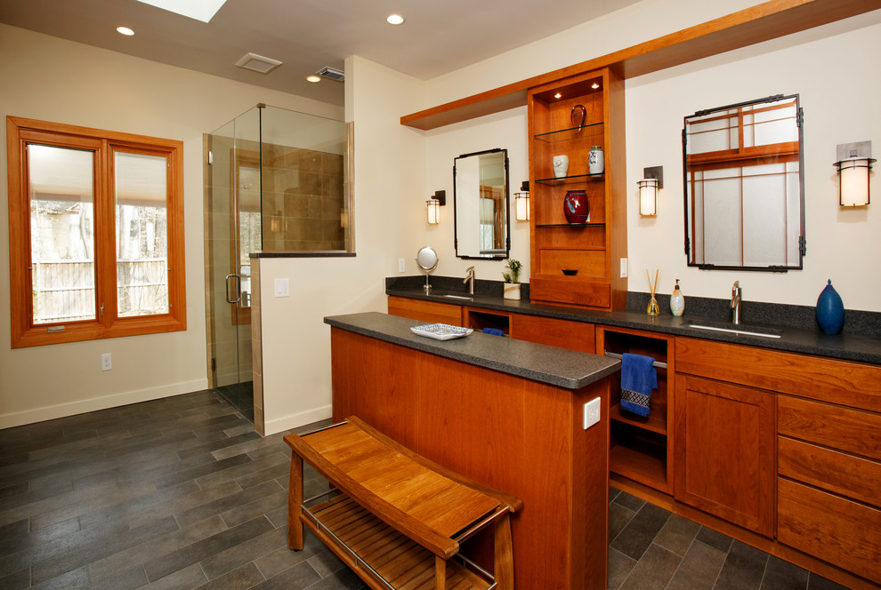 Immagine di una stanza da bagno con doccia etnica con lavabo sottopiano, ante con riquadro incassato, ante in legno scuro, doccia alcova e pareti beige