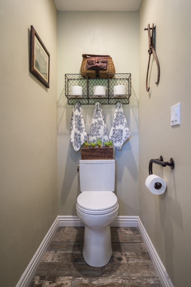 Foto di un bagno di servizio country di medie dimensioni con WC a due pezzi, pareti beige e pavimento in legno massello medio