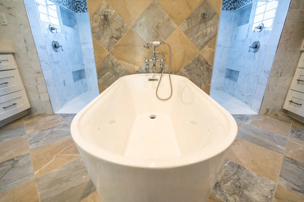 Идея дизайна: большая главная ванная комната в классическом стиле с фасадами с утопленной филенкой, белыми фасадами, отдельно стоящей ванной, двойным душем, раздельным унитазом, серой плиткой, желтой плиткой, плиткой из известняка, разноцветными стенами, полом из известняка, врезной раковиной, мраморной столешницей, разноцветным полом, открытым душем и серой столешницей