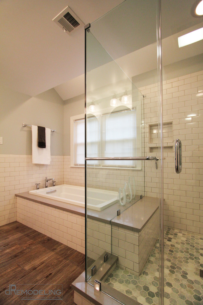 Klassisk inredning av ett mellanstort en-suite badrum, med skåp i shakerstil, vita skåp, ett platsbyggt badkar, vit kakel, ett avlångt handfat, vita väggar, klinkergolv i keramik och tunnelbanekakel