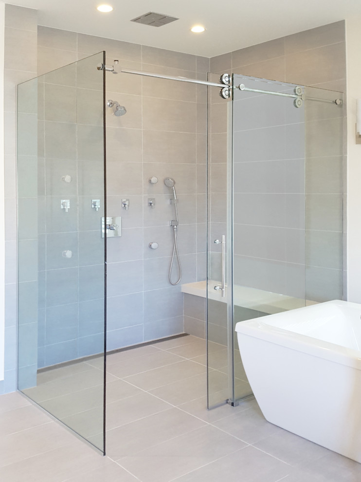 Стильный дизайн: главная ванная комната в современном стиле с душем без бортиков, серой плиткой, керамогранитной плиткой, бежевыми стенами, полом из керамогранита, серым полом и душем с раздвижными дверями - последний тренд