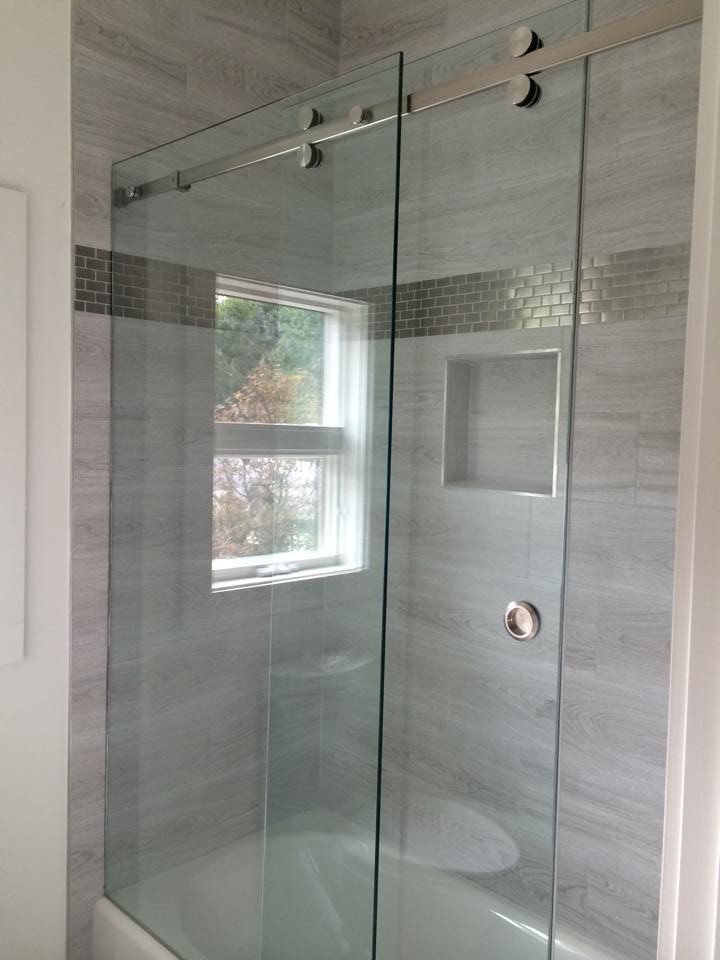 Immagine di una stanza da bagno con doccia moderna di medie dimensioni con vasca ad alcova, doccia alcova, WC a due pezzi, piastrelle grigie e pavimento in gres porcellanato