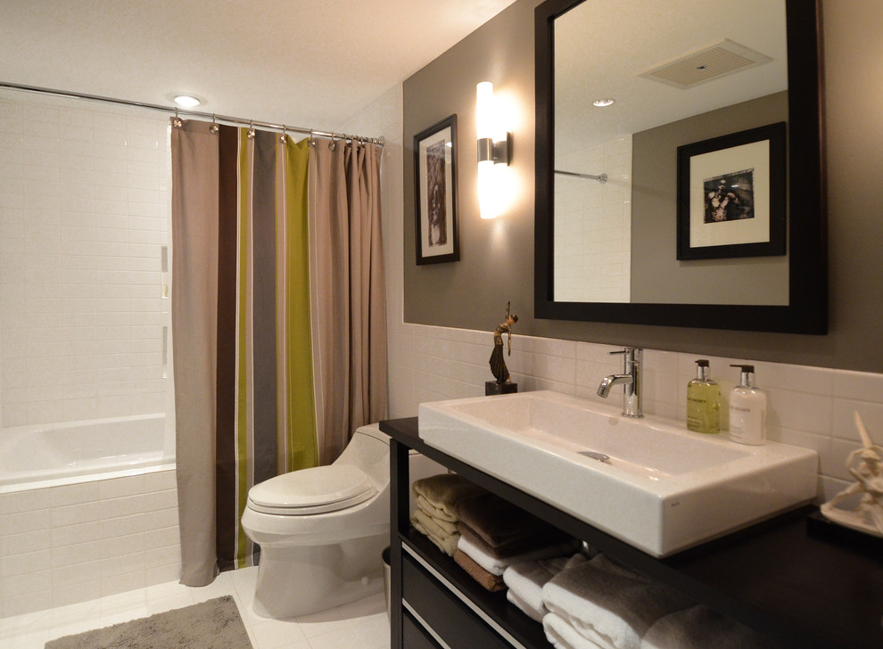 Medium sized contemporary family bathroom in Baltimore with a shower/bath combination, white tiles, a vessel sink, white floors, a shower curtain, dark wood cabinets, an alcove bath, a one-piece toilet, ceramic tiles, beige walls, ceramic flooring, wooden worktops, brown worktops, a single sink and a freestanding vanity unit.