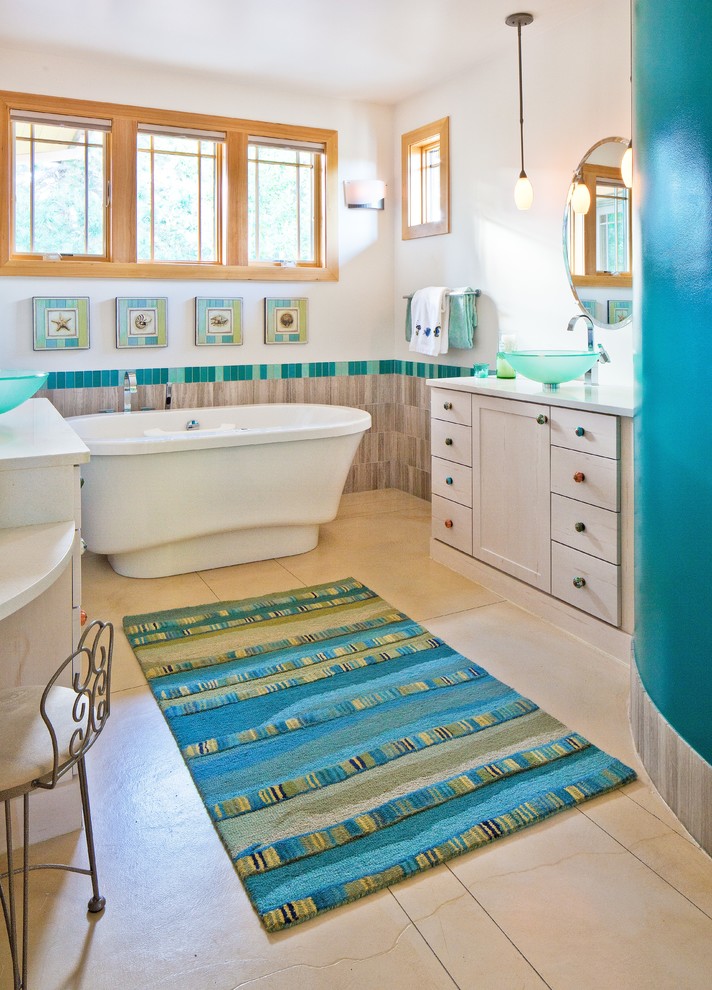 Example of an arts and crafts multicolored tile and glass tile concrete floor freestanding bathtub design in Denver with a vessel sink, shaker cabinets, beige cabinets, marble countertops and white walls