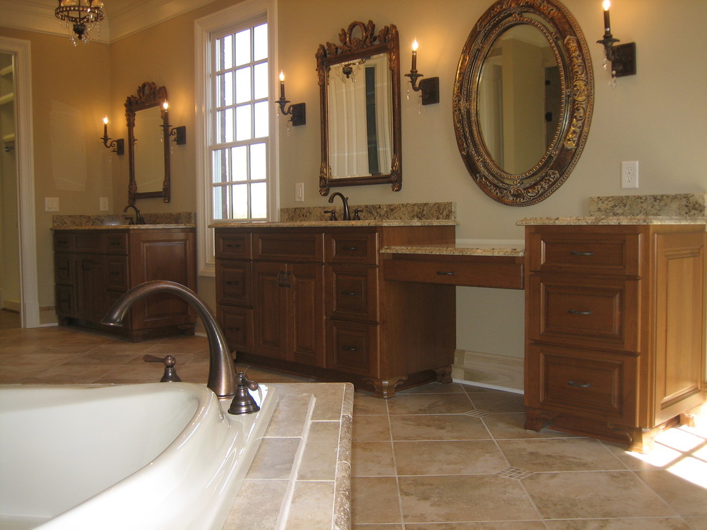 Inredning av ett klassiskt stort en-suite badrum, med luckor med infälld panel, skåp i mellenmörkt trä, ett platsbyggt badkar, beige väggar, ett undermonterad handfat, granitbänkskiva och beiget golv