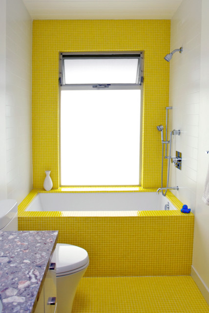 Aménagement d'une salle de bain rétro de taille moyenne pour enfant avec des portes de placard blanches, un plan de toilette en marbre, un carrelage jaune, un carrelage en pâte de verre, un sol en carrelage de terre cuite, un placard à porte plane, une baignoire en alcôve, un combiné douche/baignoire, un mur jaune et WC séparés.
