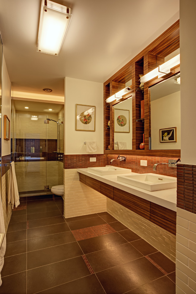 Mid-sized trendy master beige tile and subway tile porcelain tile and brown floor doorless shower photo in San Francisco with a drop-in sink, flat-panel cabinets, medium tone wood cabinets, solid surface countertops, white walls, a hinged shower door and a wall-mount toilet